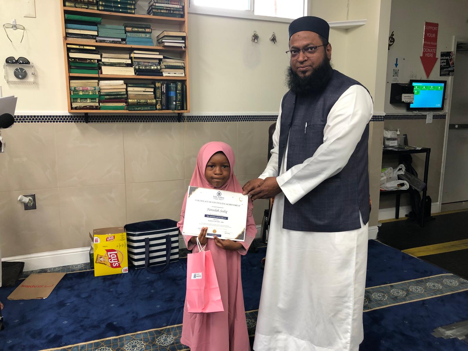 Student receiving certificate from teacher